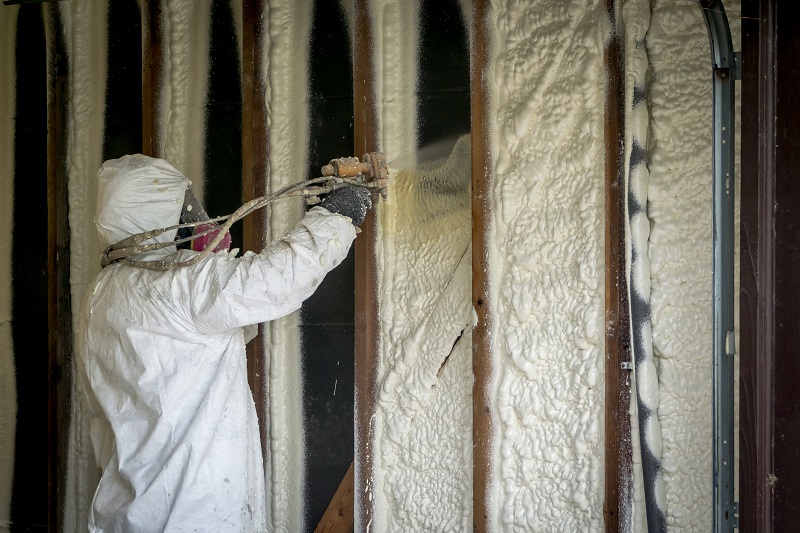 Worker spraying closed cell spray foam insulation on a home that was flooded by Hurricane Harvey Spray Foam Insulation Contractors Make Sure Your Home Is Energy Efficient