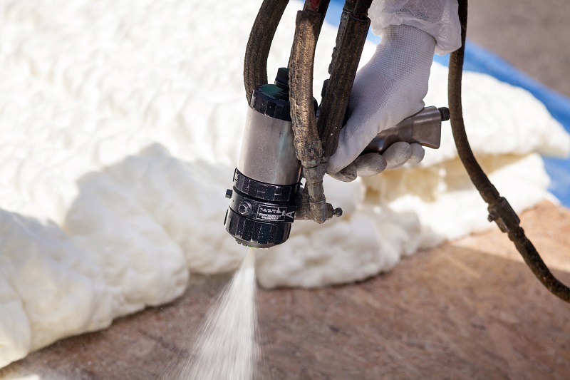 Technician spraying foam insulation using Plural Component Spray Gun Insulation Services Include The Star Difference