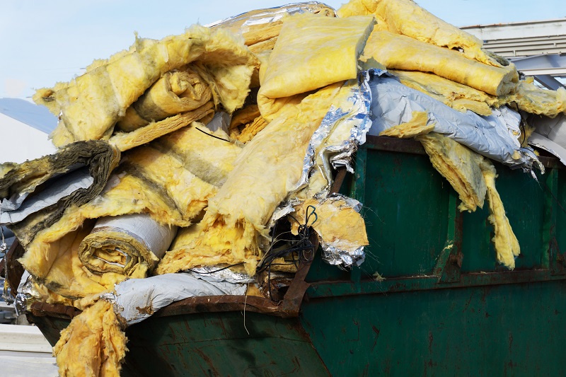 Construction waste in a metal container. Disposal of hazardous industrial waste. Close-up Insulation Companies Can Assist In Insulation Removal